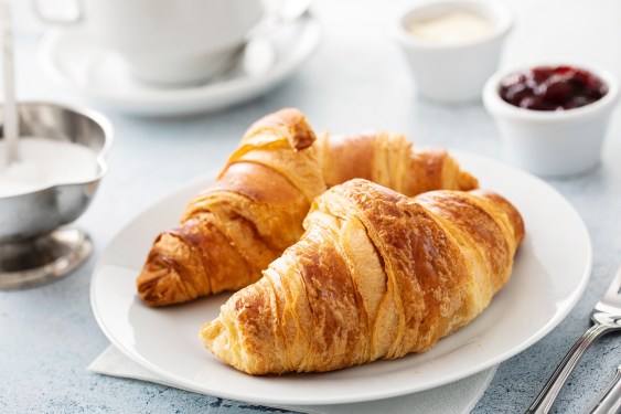 Close up of continental breakfast table with croissants and coffee cup