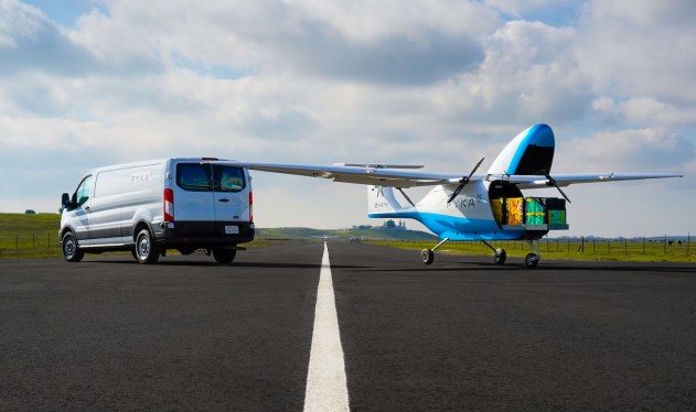 Pyka Pelican Cargo 4 parked on tarmac next to delivery van
