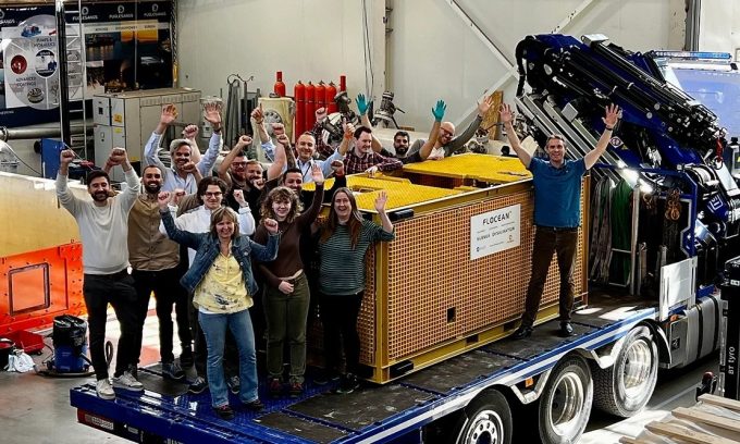 The Flocean team stands in front of a desalination pod.