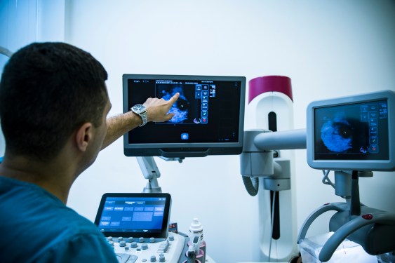 Doctor examining breasts with mammogram