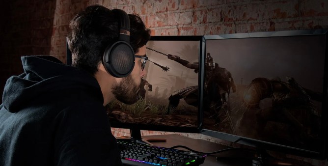 Man sitting in front screens, gaming