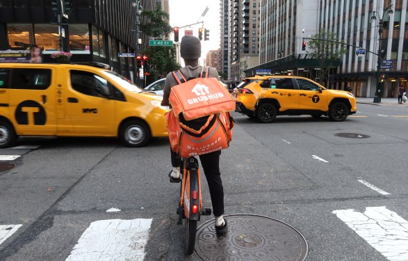 A delivery person for Grubhub rides an e-bike along Third Avenue on June 13, 2024, in New York City.