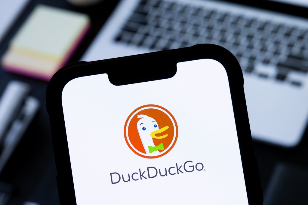 a DuckDuckGo logo is seen displayed on a smartphone