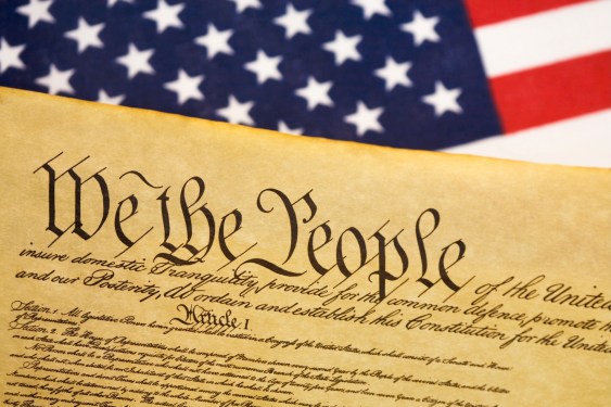 a photo of the US Constitution next to a US flag