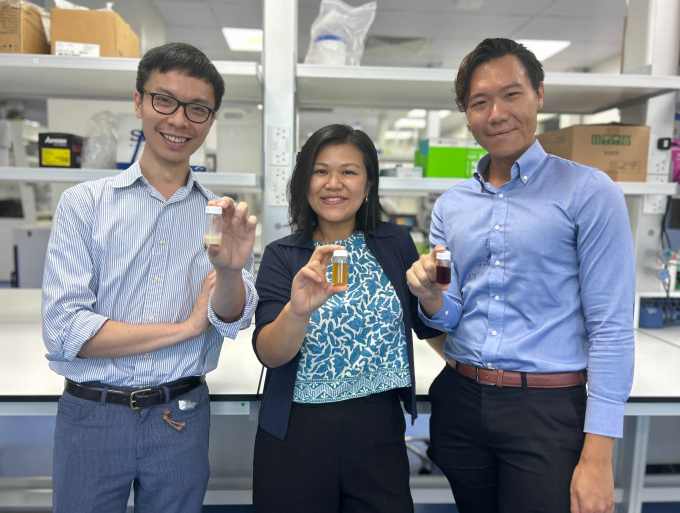 Terra Oleo's founding team stand in a lab holding vials of oil.